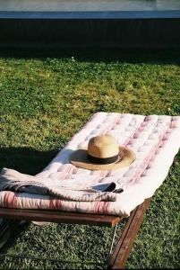 um chapéu está sentado em um cobertor em um banco em Casa da Mata em Torres Novas