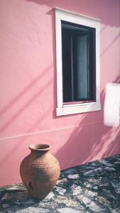 um vaso sentado ao lado de um edifício rosa com uma janela em Casa da Mata em Torres Novas