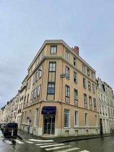un bâtiment dans une rue avec une voiture garée devant dans l'établissement Royal Hôtel Angers, à Angers