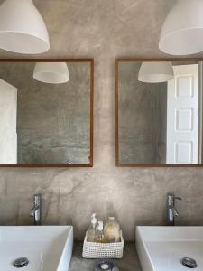 dois lavatórios numa casa de banho com dois espelhos em Casa da Mata em Torres Novas