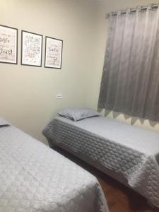 two twin beds in a room with a window at IDEAL HOTEL in Cascavel