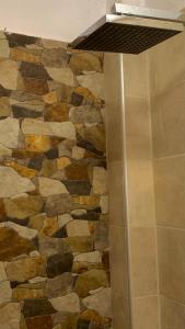 a stone wall in a bathroom with a shower at City view apartments 3’ in Serres