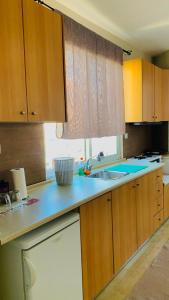 a kitchen with wooden cabinets and a sink and a window at City view apartments 3’ in Serres