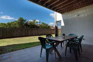 a wooden table and chairs on a patio at On The Beach & Golf Course Minutes from MTB Trails in Low Head