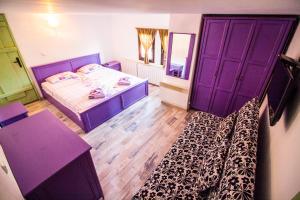 a bedroom with two beds and purple doors at Стальовата Къща in Prokhod