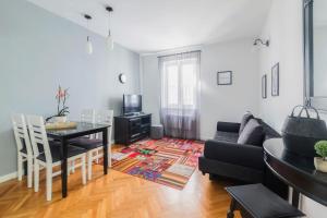 uma sala de estar com um sofá preto e uma mesa em M&A Apartments em Zadar