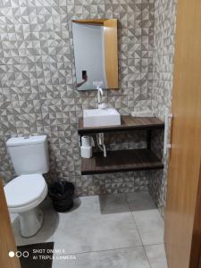 a bathroom with a toilet and a sink and a mirror at IDEAL HOTEL in Cascavel