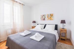 a bedroom with a large bed with two towels on it at M&A Apartments in Zadar