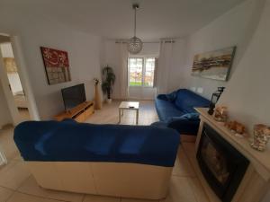 sala de estar con sofá azul y chimenea en Sonho de férias, en Portimão