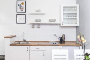 a kitchen with white cabinets and a sink at M&A Apartments in Zadar +34 photos