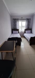a room with two beds and a window at Matat Studio Apartments in Matatiele