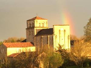 Charmante maison, vue imprenable في Nanclars: كنيسة قديمة بها قوس قزح أمامها
