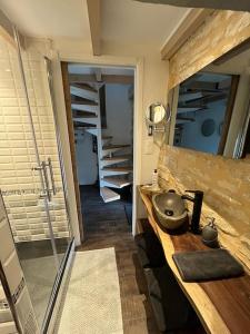 uma casa de banho com um lavatório e um espelho num balcão em Charmante maison, vue imprenable em Nanclars