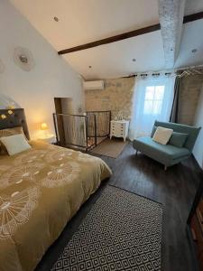 Charmante maison, vue imprenable في Nanclars: غرفة نوم بسرير كبير وكرسي ازرق