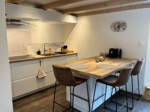 a kitchen with a table and chairs in a kitchen at La Petite Maison - La Grange des Colporteurs in Nanclars