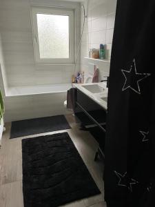 a bathroom with a sink and a black rug at Villa am Fluß in Pforzheim
