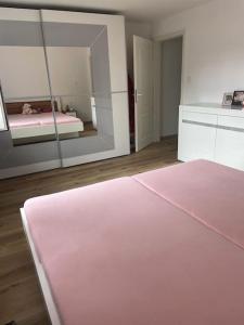 a bedroom with a pink bed and a mirror at Villa am Fluß in Pforzheim