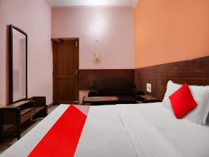 a hotel room with a bed and a chair at OYO Flagship Jaiswal Star Stay in Lucknow