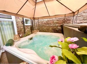 a jacuzzi tub in a tent with pink flowers at *Brecon Beacons,Log Burner, hot tub Dogs Welcome* in Crickhowell