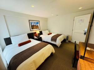 a hotel room with two beds and a television at LP Los Portales Hotel Cusco in Cusco