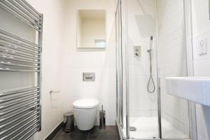 a bathroom with a shower and a toilet and a sink at Classy Modern Flat: Free Parking, Gym & Roof Garden in Stevenage