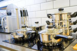 a group of pots and pans on a stove in a kitchen at Classy Modern Flat: Free Parking, Gym & Roof Garden in Stevenage