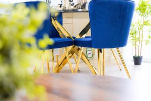 dos sillas azules sentadas junto a una mesa en Classy Modern Flat: Free Parking, Gym & Roof Garden en Stevenage