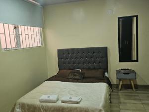 a bedroom with a large bed with two towels on it at Roma House N- suite Campin Movistar Ministerios Simón Bolivar in Bogotá