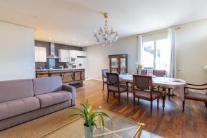 sala de estar con sofá, mesa y sillas en Appartement Duplex, en Le Thillay