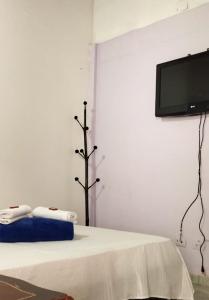 Habitación con cama y TV en la pared. en Hostal Kuyay en Filandia