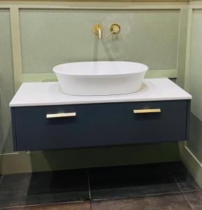 a bathroom sink with a bowl on top of it at Grey Heron Townhouse in Newcastle