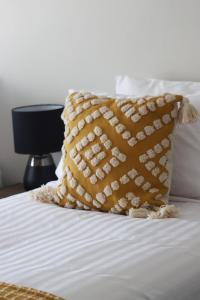 - un oreiller jaune assis au-dessus du lit dans l'établissement Canonbar Motel, à Nyngan
