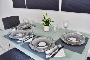 - une table à manger avec des assiettes et des verres à vin dans l'établissement Bel appartement au cœur de Nice (2 chambres), à Nice 10 autres photos