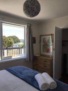 um quarto com uma cama e uma grande janela em Costal Canvas opononi em Opononi