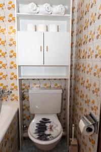 a bathroom with a toilet with a shelf above it at Chalet d'appartement avec une grande terrasse in Torgon