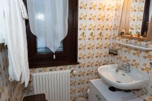 a bathroom with a sink and a toilet and a window at Chalet d'appartement avec une grande terrasse in Torgon