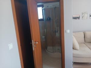 a bathroom with a shower and a glass door at Къща за гости В 12 и 5 in Dolna Banya