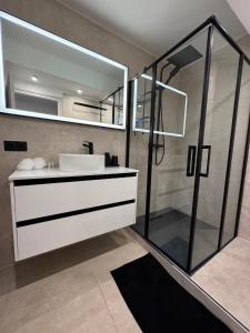 bagno con lavandino bianco e specchio di Appartement Hyper-Centre Megeve - ski à pied a Megève