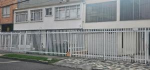 a white fence in front of a house at Roma Lodges House - Turin- Campin Movistar Embajada cubo colsubsidio in Bogotá
