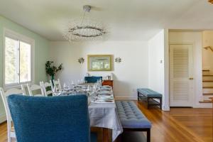 uma sala de jantar com uma mesa longa e cadeiras azuis em Private Heated Pool - Sparkling Oasis Near Newport & Navy, 4bd 3ba em Middletown
