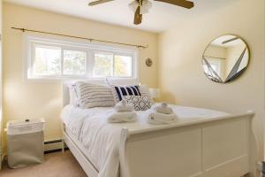 um quarto com uma cama branca e toalhas em Private Heated Pool - Sparkling Oasis Near Newport & Navy, 4bd 3ba em Middletown