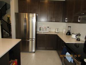 a kitchen with a stainless steel refrigerator and wooden cabinets at Moral’s Inn- Ottawa in Ottawa