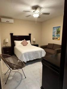 プエルト・モレロスにあるCasa Pelicanoのベッドとソファのある寝室