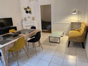 a living room with a table and yellow chairs at Joli Appartement centre Nevers in Nevers