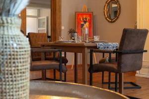 a dining room with a table with chairs and a mirror at Avancers - homelike living in Cottbus