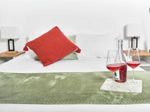 - deux verres de vin rouge sur une couverture verte sur un lit dans l'établissement BALCON BLANC - Auberge à Chicoutimi, Saguenay, à Saguenay