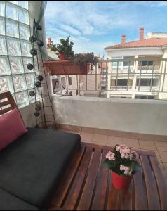 a balcony with a couch and flowers on a roof at Apartment San Izola - near the beach in Izola
