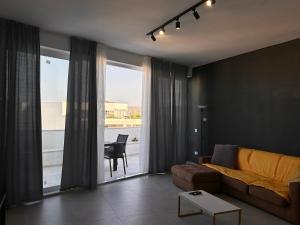 uma sala de estar com um sofá e uma grande janela em Qawra penthouse 4person AC+wifi em St. Paul's Bay