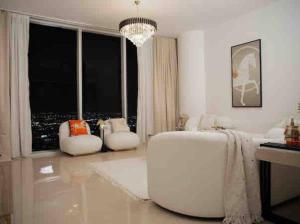 - un salon blanc avec un lustre dans l'établissement شقة فندقيه في برج رافال Rafal Tower الدور 53, à Riyad