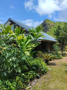 una casa con un montón de plantas delante de ella en Tema'e Beach House en Temae